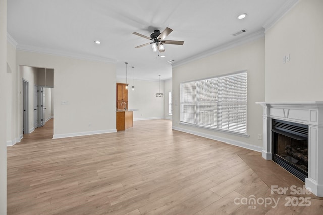 unfurnished living room featuring ceiling fan, light wood-style flooring, a fireplace, visible vents, and ornamental molding