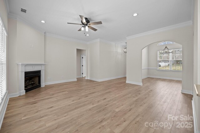 unfurnished living room featuring light wood-type flooring, a fireplace with flush hearth, baseboards, and ceiling fan with notable chandelier