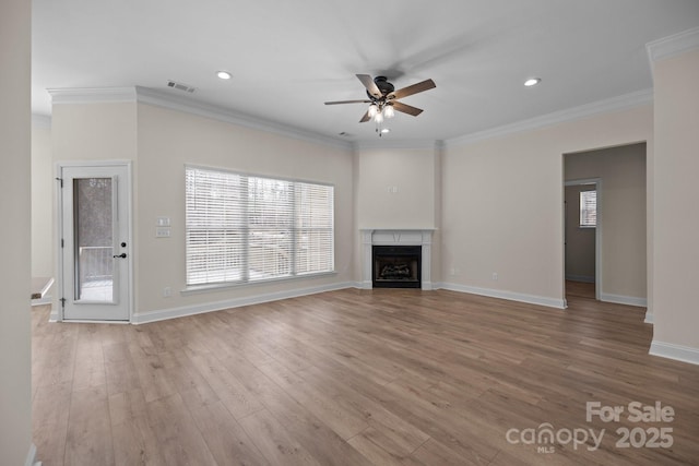 unfurnished living room with a ceiling fan, a fireplace, ornamental molding, and wood finished floors