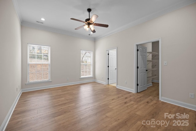 unfurnished bedroom featuring baseboards, visible vents, crown molding, and light wood finished floors