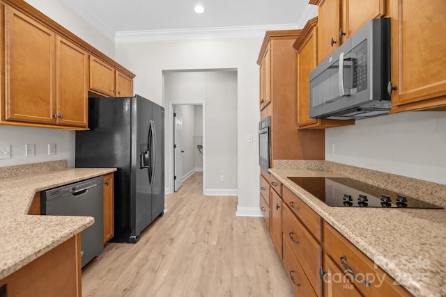 kitchen featuring black appliances, light wood-type flooring, brown cabinets, and crown molding