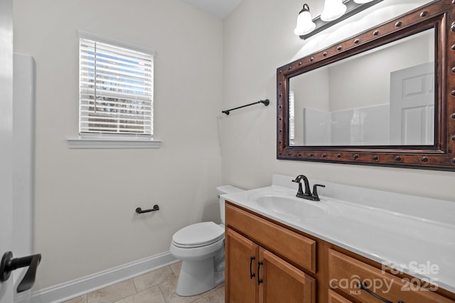 bathroom with baseboards, vanity, toilet, and tile patterned floors