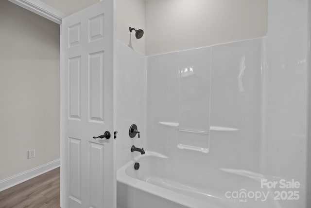 full bathroom featuring shower / bath combination, baseboards, and wood finished floors