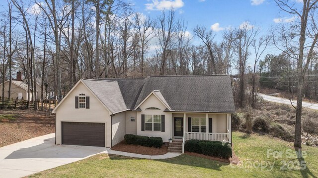 view of front of home with a front yard, covered porch, roof with shingles, and concrete driveway