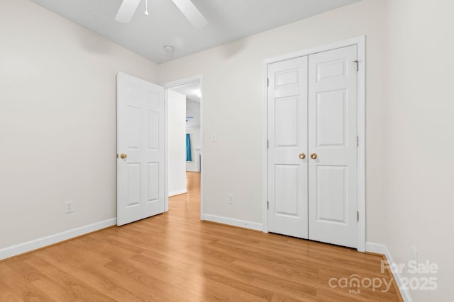 unfurnished bedroom with light wood-style floors, baseboards, and a closet