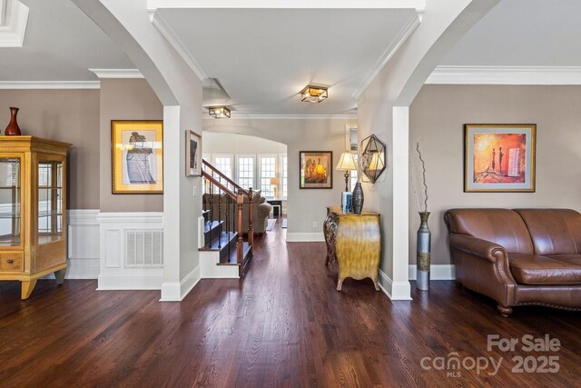 foyer entrance featuring visible vents, wood finished floors, and crown molding