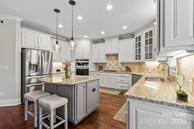 kitchen featuring a sink, dark wood finished floors, a center island, white cabinetry, and stainless steel appliances