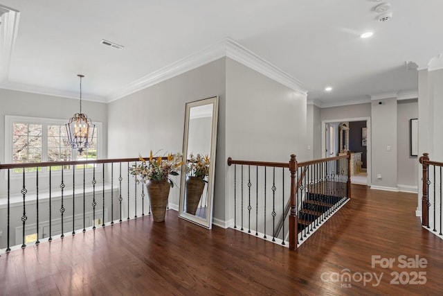 corridor featuring visible vents, an upstairs landing, wood finished floors, an inviting chandelier, and baseboards