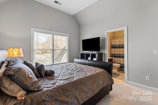 bedroom with baseboards, visible vents, lofted ceiling, light carpet, and connected bathroom