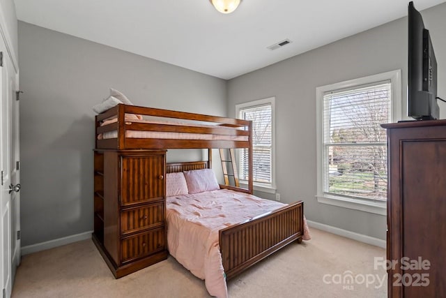 bedroom with light carpet, visible vents, and baseboards