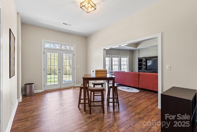 dining room with french doors, plenty of natural light, baseboards, and dark wood-style flooring