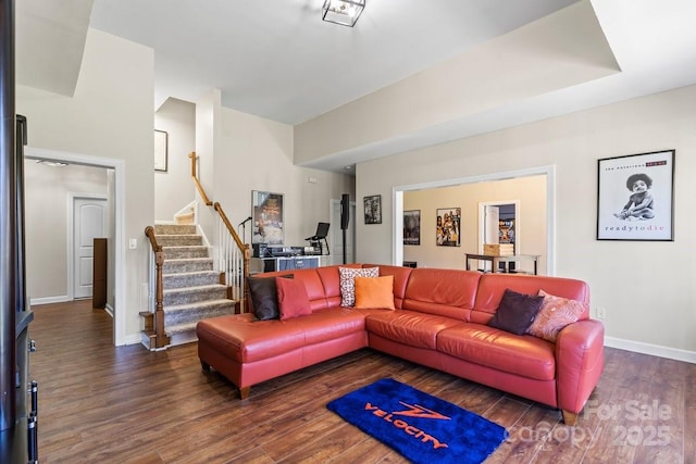 living area with stairway, baseboards, and wood finished floors