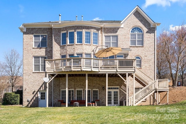 back of property with stairs, a lawn, brick siding, and a wooden deck