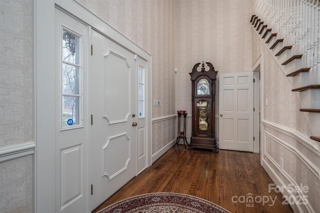 entryway with wallpapered walls, dark wood finished floors, and wainscoting