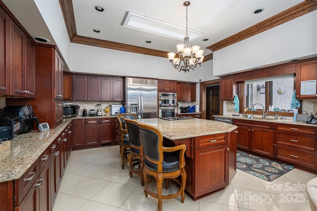 kitchen featuring a sink, ornamental molding, stainless steel appliances, a chandelier, and a center island