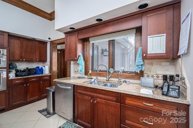 kitchen with a sink, light stone countertops, ornamental molding, and light tile patterned floors