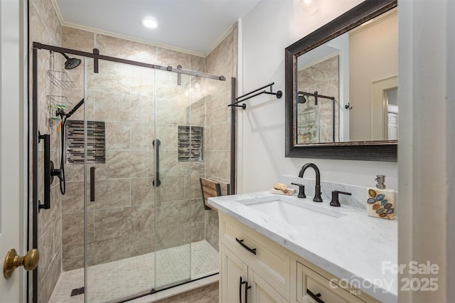 bathroom featuring vanity, ornamental molding, and a shower stall