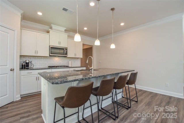 kitchen featuring dark wood-type flooring, tasteful backsplash, stainless steel appliances, and a sink