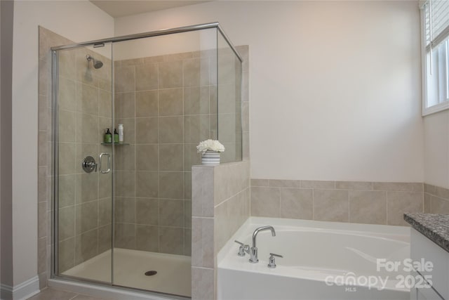 full bathroom featuring a garden tub and a shower stall