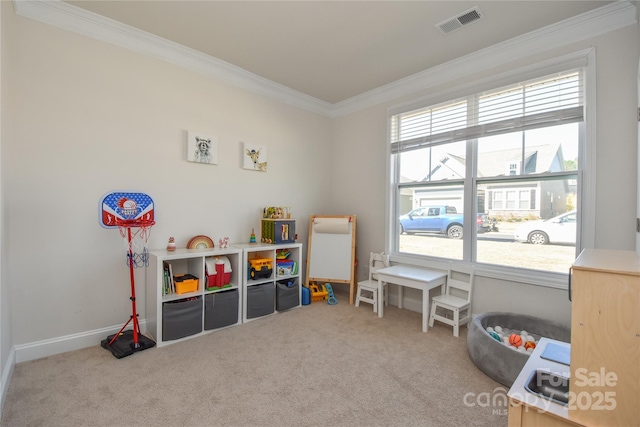 recreation room with carpet floors, ornamental molding, visible vents, and baseboards