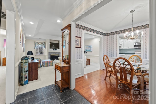 dining space with wallpapered walls, a chandelier, ornamental molding, recessed lighting, and a fireplace