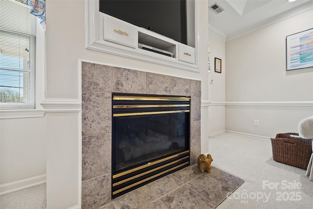 details featuring baseboards, visible vents, carpet floors, a tile fireplace, and crown molding