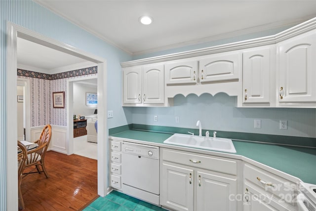 kitchen featuring a sink, wallpapered walls, white cabinets, wainscoting, and white dishwasher