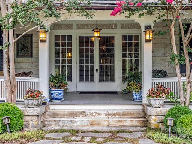 view of exterior entry with french doors and a porch