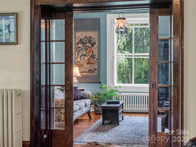 sitting room featuring radiator and wood finished floors