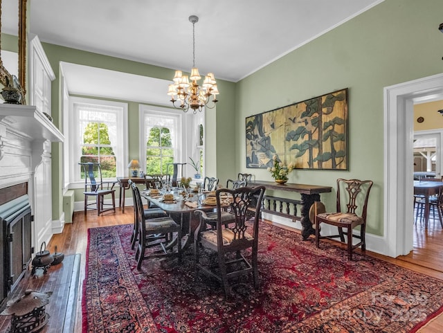 dining space featuring baseboards, an inviting chandelier, ornamental molding, and hardwood / wood-style flooring