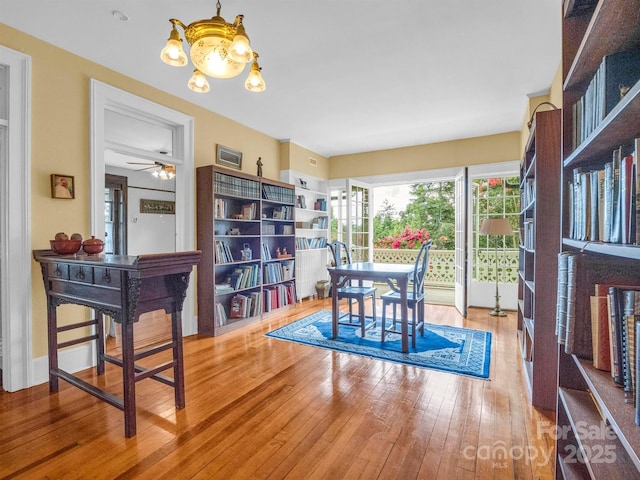 dining space with hardwood / wood-style floors and an inviting chandelier