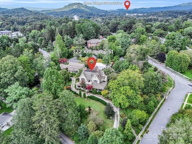 birds eye view of property featuring a forest view and a mountain view