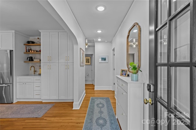 interior space featuring open shelves, light countertops, freestanding refrigerator, white cabinets, and light wood-type flooring