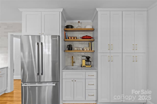 kitchen featuring ornamental molding, open shelves, light countertops, and freestanding refrigerator