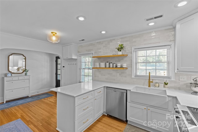 kitchen featuring visible vents, range, a peninsula, stainless steel dishwasher, and a sink