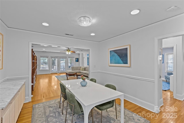 dining space featuring light wood finished floors, baseboards, visible vents, and recessed lighting