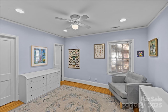 sitting room featuring visible vents, baseboards, ceiling fan, ornamental molding, and light wood-style floors