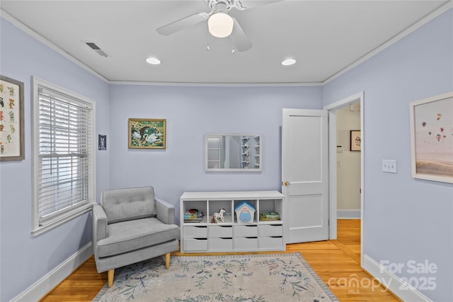 living area featuring wood finished floors, visible vents, and baseboards