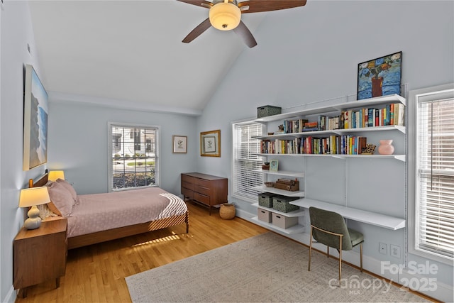 bedroom featuring high vaulted ceiling, built in study area, ceiling fan, and light wood finished floors