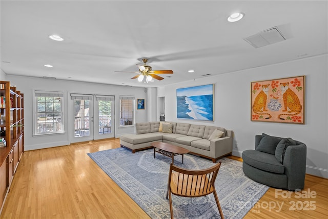 living room featuring light wood-style floors, recessed lighting, visible vents, and baseboards