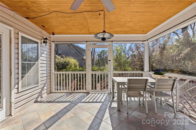 sunroom with a healthy amount of sunlight, wood ceiling, and vaulted ceiling