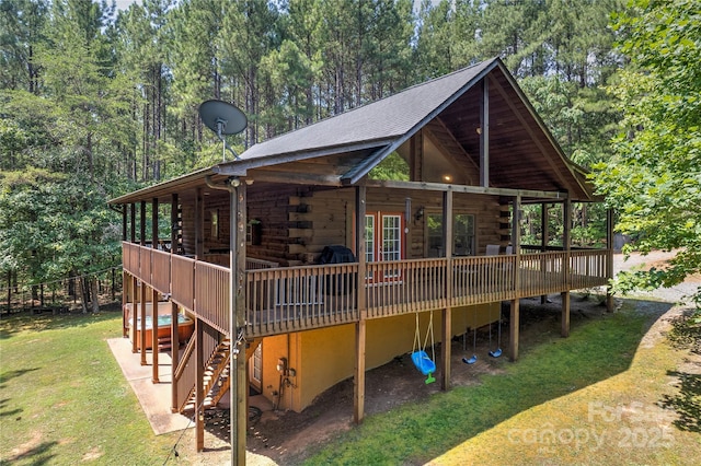 view of property exterior with a yard, stairway, log siding, and a view of trees