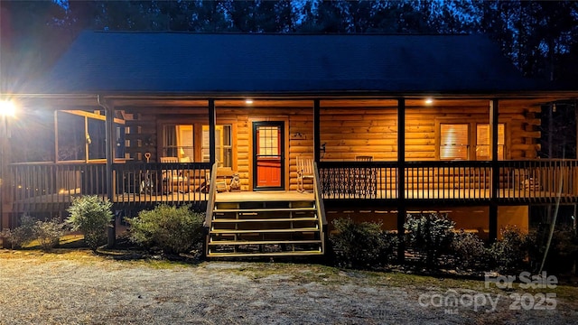 view of front of home with a porch and log exterior