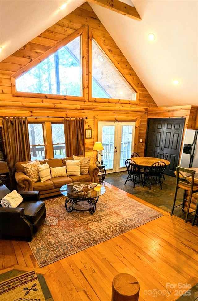 living room featuring wood walls, plenty of natural light, and dark wood-type flooring