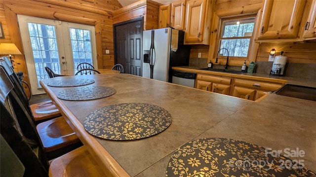 kitchen with appliances with stainless steel finishes, a breakfast bar, french doors, and a sink