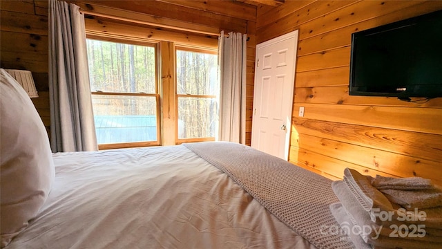 bedroom featuring wood walls