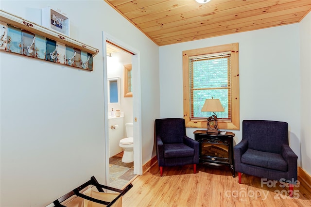 living area with light wood-type flooring, wooden ceiling, and baseboards