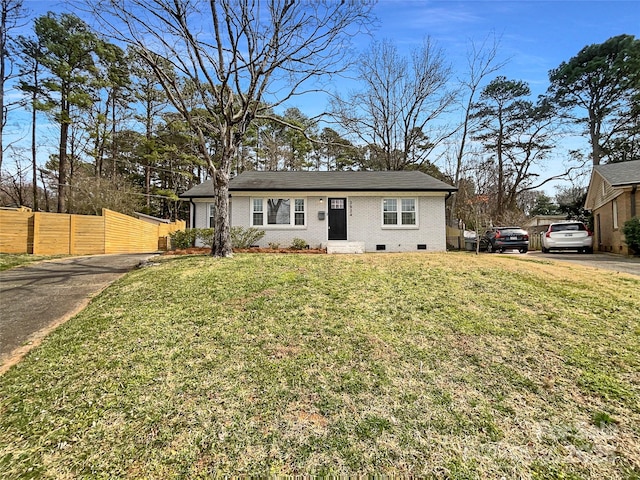 view of front of house with crawl space, a front yard, fence, and brick siding