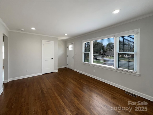 entrance foyer with crown molding, wood finished floors, visible vents, and baseboards