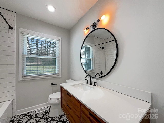 bathroom with toilet, vanity, and baseboards